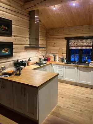a large kitchen with wooden walls and a counter top at Large Log Cabin, Ski Fun Near Dagali in Dagali