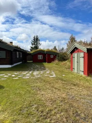 a yard with two red and white buildings at Charming Cabin Near Rondane National Park in Venabygd