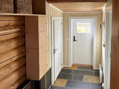 a hallway of a house with a door and a room with a door at Charming Cabin Near Rondane National Park in Venabygd