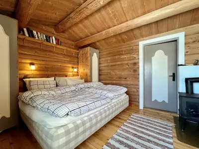 a bedroom with a bed in a room with wooden walls at Charming Cabin Near Rondane National Park in Venabygd