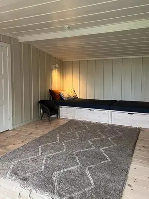 a living room with a couch and a rug at Charming Cabin Near Rondane National Park in Venabygd