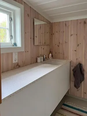 a kitchen with wooden walls and a white counter top at Charming Cabin Near Rondane National Park in Venabygd