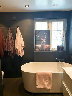 a bathroom with a tub and a deer in a window at Authentic Cabin Hygge All Year Round At Hafjell in Øyer