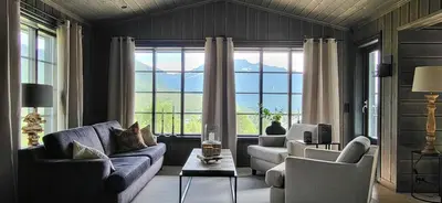 a living room with two couches and a large window at Modern Cabin With Ski Inout In Great Area in Brunstad