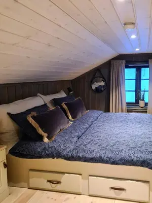 a bedroom with a bed with blue comforter and pillows at Modern Cabin With Ski Inout In Great Area in Brunstad