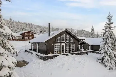 a log cabin in the snow with snow covered trees at Relax By The Ski Tracks In A Cabin At Sjusjøen in Sjusjøen