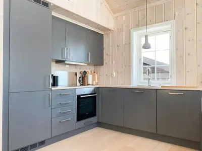 a kitchen with gray cabinets and a window at Relax By The Ski Tracks In A Cabin At Sjusjøen in Sjusjøen