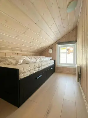 a bed in a small room with a window at Relax By The Ski Tracks In A Cabin At Sjusjøen in Sjusjøen
