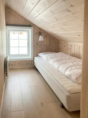 a large bed in a room with a window at Relax By The Ski Tracks In A Cabin At Sjusjøen in Sjusjøen