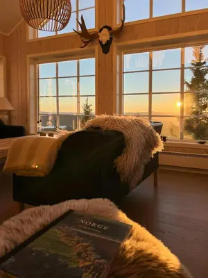 a living room with a couch in a room with windows at Modern Mountain Cabin With Panoramic Views in Sjusjøen
