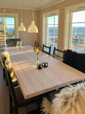 a dining room table with chairs and a large wooden table at Modern Mountain Cabin With Panoramic Views in Sjusjøen