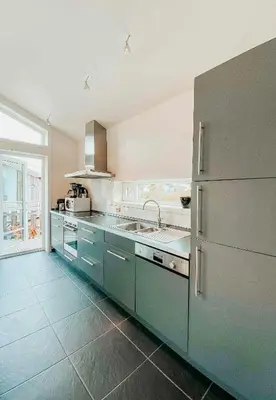 a kitchen with a sink and a refrigerator at Charming Cabin Overlooking Vegglifjell in Kravikfjord