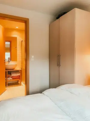 two beds in a room with a sink and a bathroom at Charming Cabin Overlooking Vegglifjell in Kravikfjord