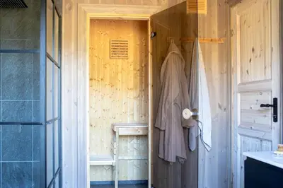 a bathroom with a closet with a robe on a door at Secluded Mountain Cabin In Rauland With View in Brunstad
