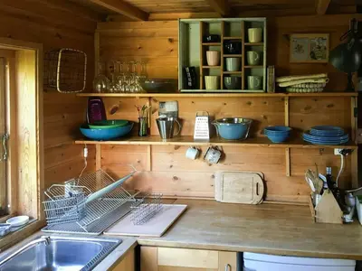a kitchen with a sink and a counter with dishes at Charming Artist's Cabin With Sea View Near Bergen in Straume