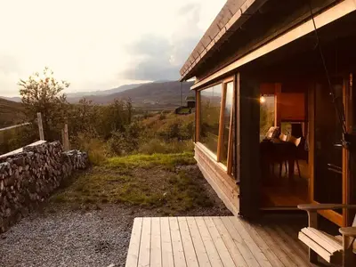 a person sitting at a table outside of a house at Mountain Cabin With Stunning View In Ål in Ål