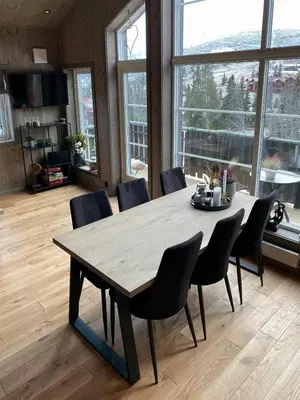 a dining room table and chairs in a room with windows at Modern Cabin In Trysil With Mountain Views in Trysil