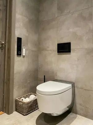 a bathroom with a toilet and a television on the wall at Modern Cabin In Trysil With Mountain Views in Trysil