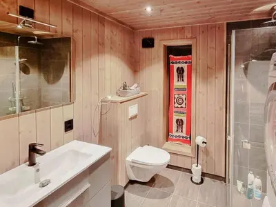 a bathroom with a white toilet and a sink at Stylish Modern Cabin In Charming Kvitfjell in Favang