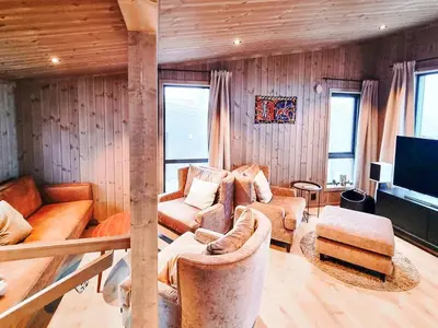 a living room with couches and a tv in it at Stylish Modern Cabin In Charming Kvitfjell in Favang