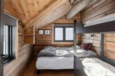 a bedroom with two beds in a log cabin at Modern And Spacious Cabin At Mosetertoppen in Øyer