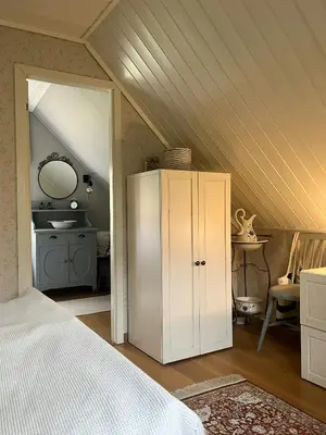 a bedroom with a white cabinet in a attic at Cabin With Shoreline By Brusdalsvannet Lake in Ålesund