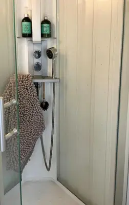 a shower with a glass door in a room at Cabin With Shoreline By Brusdalsvannet Lake in Ålesund