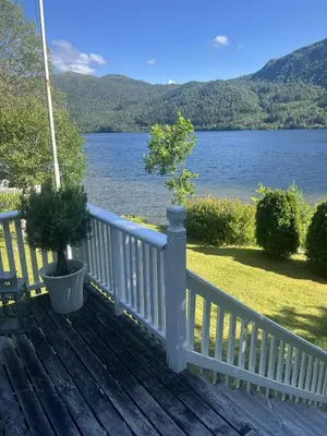 a wooden deck with a view of a lake at Cabin With Shoreline By Brusdalsvannet Lake in Ålesund