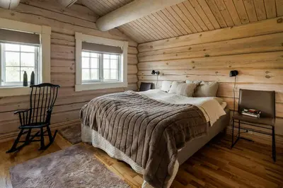 a bedroom with a bed and a wooden wall at Cozy And Spacious Family Cabin In Valdres in Bagn