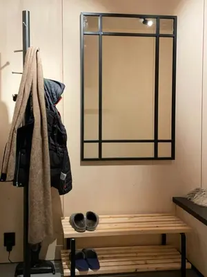 a mirror hanging on a wall next to a bench at Peaceful Nature And Design On Skardsøya in Lesund