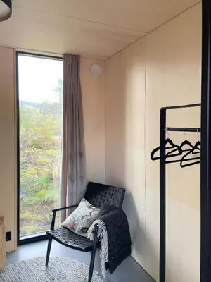 a small room with a chair and a window at Peaceful Nature And Design On Skardsøya in Lesund