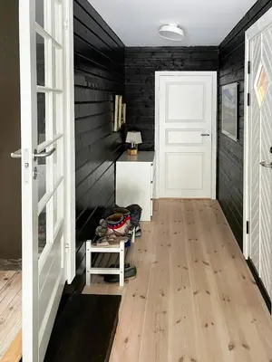 a hallway with black walls and a white door at Cabin With Mountain View Near Lake Totak in Rauland