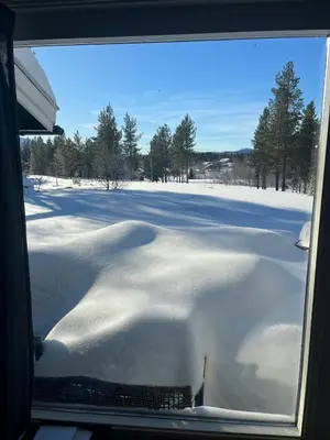 a view of a snow covered field through a window at Cabin With Mountain View Near Lake Totak in Rauland