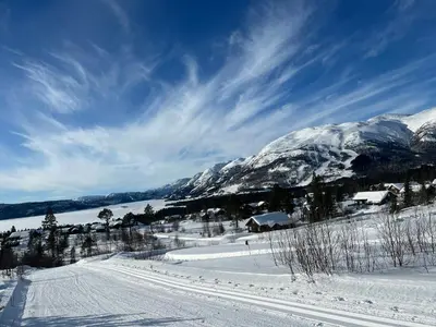 a snowy road with snow covered mountains in the background at Cabin With Mountain View Near Lake Totak in Rauland