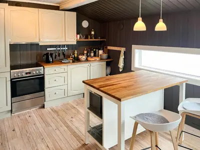 a kitchen with white cabinets and a wooden table at Cabin With Mountain View Near Lake Totak in Rauland