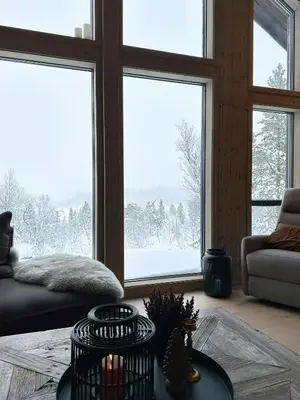 a living room with a large window with snow outside at Modern Mountain Home At Nerskogen, Trollheimen in Nerskogen