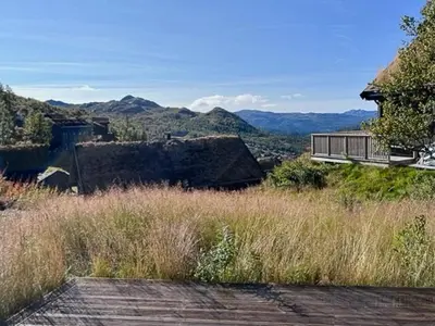 a house on a hill with mountains in the background at Modern Cabin With View In Rauland in Rauland