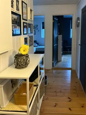 a room with a vase with a yellow flower on a table at Charming Cabin With Archipelago Views In Sogn in Ånneland