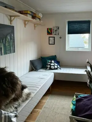 a small room with a couch and a window at Charming Cabin With Archipelago Views In Sogn in Ånneland