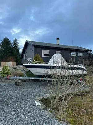 a boat on a trailer in front of a house at Charming Cabin With Archipelago Views In Sogn in Ånneland