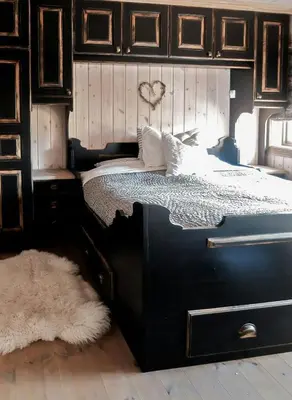 a bedroom with a black bed with wooden cabinets at Large Cabin By Farhovdtjønn In Rauland in Rauland