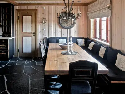 a dining room with a table and a couch at Large Cabin By Farhovdtjønn In Rauland in Rauland