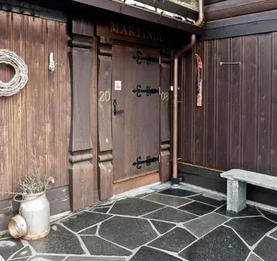 a wooden door of a building with a bench at Large Cabin By Farhovdtjønn In Rauland in Rauland