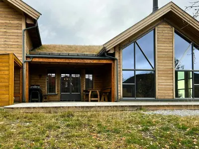 a house with a grass roof and windows at Modern Family Cabin At Vegglifjell in Veggli