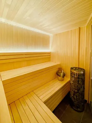 a large wooden sauna with a bench and a trash can at Enjoy Family Time In Beautiful Nature in Krøderen