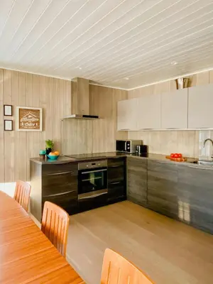 a kitchen with wooden cabinets and a table with chairs at Enjoy Family Time In Beautiful Nature in Krøderen