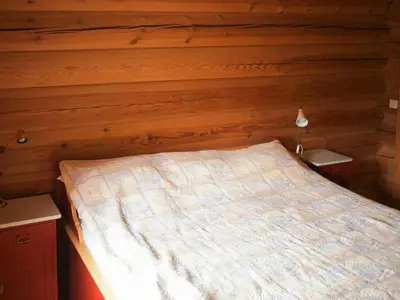 a bedroom with a bed in a log cabin at Cabin With Wooden Interior By Lake Tinnsjøen in Atra