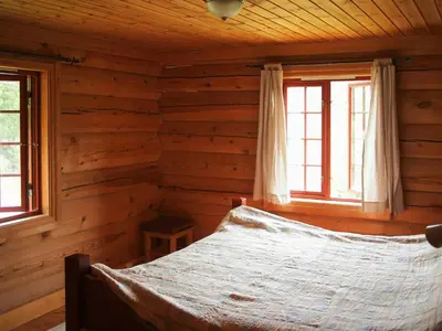 a bedroom with a bed in a log cabin at Cabin With Wooden Interior By Lake Tinnsjøen in Atra