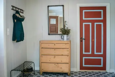 a bedroom with a dresser and a red door at Family-Friendly Cabin With Agricultural Idyll in Vestre Gausdal