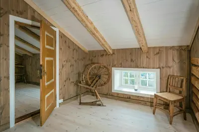 a room with a wooden wall with amill and a window at Family-Friendly Cabin With Agricultural Idyll in Vestre Gausdal